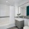 Henry Hall Bathroom with white tile walls and large mirror